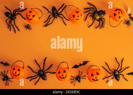 Halloween Dekorationen, Kürbisse, Fledermäuse, Spinnen auf orangefarbenem Hintergrund Stockfoto