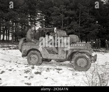 Beim Ausstieg überprüft Sgt Elvis Presley die Position auf der Karte, während er den Jeep-Fahrer Pvt anleitet. Lonnie Wolfe während der Winterschild-Übung der US-Armee Stockfoto