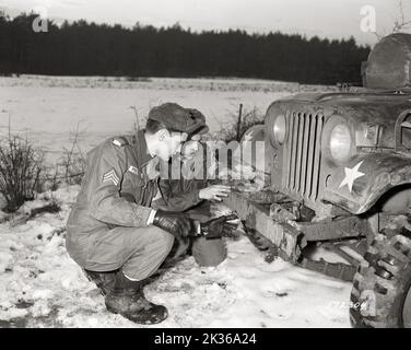 Sgt Elvis Presley überprüft Jeep mit Fellow 32. Armor Scout Pvt. Lonnie Wolfe, Fahrer von Presley's Jeep Stockfoto