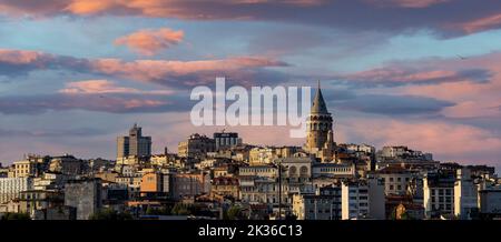 Stadtbild eines Teils der Stadt Istanbul mit Häusern und dem Galata-Turm bei Sonnenuntergang am Hafen von Eminönü. Stockfoto