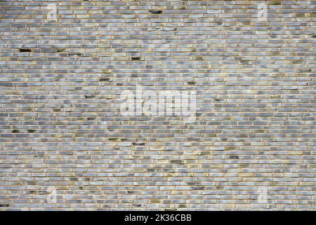 Hintergrund einer großen Mauer aus grauen Ziegeln Stockfoto