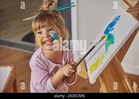Charmantes Kind zeichnet und färbt alles mit Farben Stockfoto