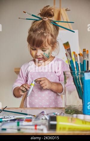 Charmantes schmutziges Kind zieht zu Hause mit Acryl Stockfoto