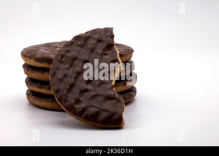 Milchschokoladenkekse in einem Stapel und zur Hälfte gegessen Stockfoto