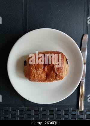 Schokoladencroissant auf einem feinen Teller von oben Stockfoto