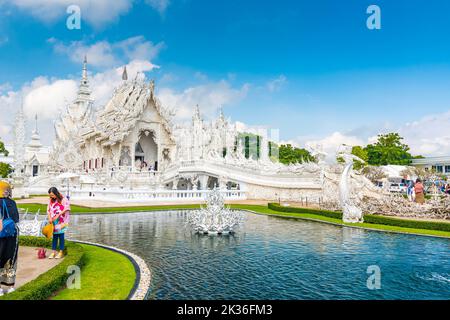 CHIANG RAI, THAILAND - 6.11.2019: Touristen besuchen den berühmten weißen Tempel (Wat Rong Khun) in der Nähe der Stadt Chiang Rai. Weißer Tempel mit Brücke über verdammte Seelen Stockfoto