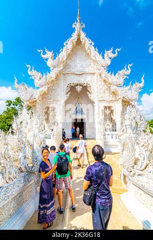 CHIANG RAI, THAILAND - 6.11.2019: Touristen besuchen den berühmten weißen Tempel (Wat Rong Khun) in der Nähe der Stadt Chiang Rai. Weißer Tempel mit Brücke über verdammte Seelen Stockfoto