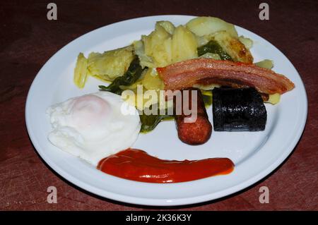 Typisches Gericht aus der Alpujarra, mit Kartoffeln, Chorizo, Paprika, Schwarzpudding und Spiegelei Stockfoto