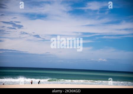 Wunderschönes, malerisches, mehrfarbiger Ozean mit Wasserhämmern, blauer Himmel mit strukturierten Wolken mit Blick auf den weichen Sandstrand Stockfoto