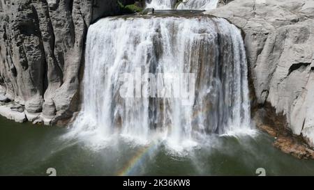 Eine wunderschöne Landschaft mit einem Wasserfall in einer felsigen Gegend an einem sonnigen Tag Stockfoto