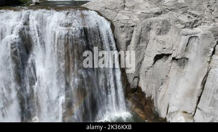 Eine wunderschöne Landschaft mit einem Wasserfall in einer felsigen Gegend an einem sonnigen Tag Stockfoto