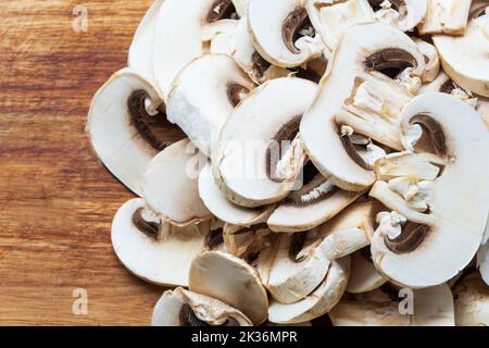 Champignons in Scheiben auf einem Schneidebrett, das fertig zum Kochen ist Stockfoto