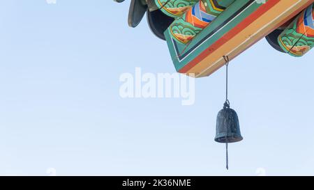 Glocke auf einem bemalten Dach mit Mustern, buddhistischer Tempel, Hintergrund Stockfoto