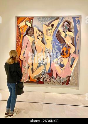 30.10.2021. Malaga, Spanien. Blondes Mädchen, das vor Pablo Picassos einem der berühmtesten Gemälde namens Les Demoiselles dAvignon im Picasso-Musseum in Malaga steht. Hochwertige Fotos Stockfoto