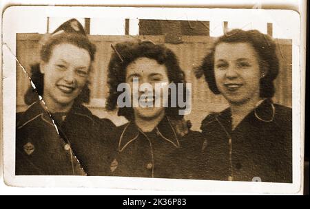 Ein Vintage-Foto von drei Naafi-Mädchen, die in der Kantine der Naafi-, Armee- und Luftwaffeninstitute (NAAFI) in Catterick, Großbritannien, arbeiten. Die Dame auf der linken Seite war Miss Rosamund Waters aus Whitby Yorkshire Gegend, andere unbekannt. Die moderne NAAFI-Organisation wurde 1921 im April 1944 gegründet und hat 7.000 Kantinen und 96.000 Angestellte sowie die Kontrolle der ENSA Forces Entertainment Group. Stockfoto