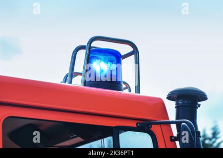 Blinkendes blaues Licht auf einem Feuerwehrauto im Einsatz, Teil des Fahrzeugs, Kopierraum am Himmel, Bewegungsunschärfe, ausgewählter Fokus Stockfoto