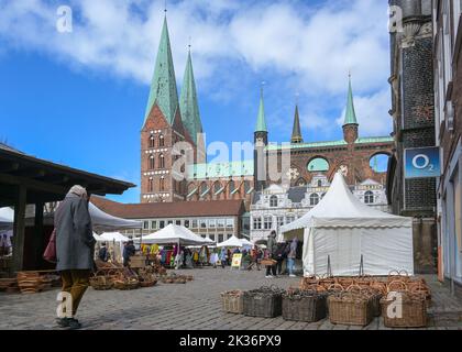 Lübeck, 10. April 2022: Kunst- und Handwerksmarkt mit Zelten und Ständen in der Innenstadt am Rathaus und der Marienkirche, blauer Himmel mit Stockfoto