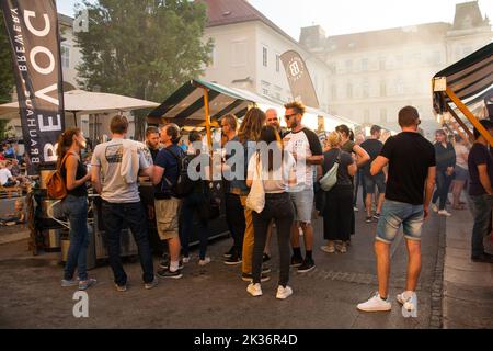 Ljubljana, Slowenien - 3. 2022. September.Touristen und Einheimische genießen Speisen und Getränke auf einem Straßenmarkt in Pogacarjev Trg, im Zentrum von Ljubljana Stockfoto