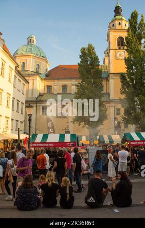 Ljubljana, Slowenien - 3. 2022. September.Touristen und Einheimische genießen Speisen und Getränke auf einem Straßenmarkt in Pogacarjev Trg, im Zentrum von Ljubljana Stockfoto