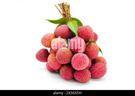 Ein Haufen pinkfarbener Lychee-Früchte mit grünen Blättern, isoliert auf weißem Hintergrund Stockfoto