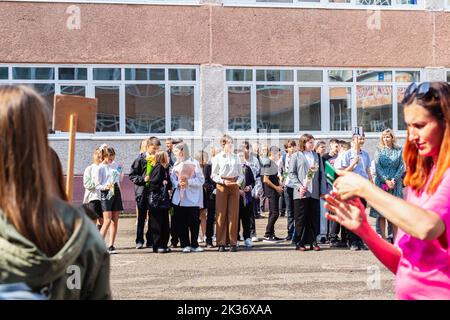 Tomsk Russland September 1,2022 Kinder gehen zurück in die Schule, erster Schultag.glücklich lächelnde Lehrer und Schüler auf dem Schulhof am Tag des Wissens. Oder Stockfoto