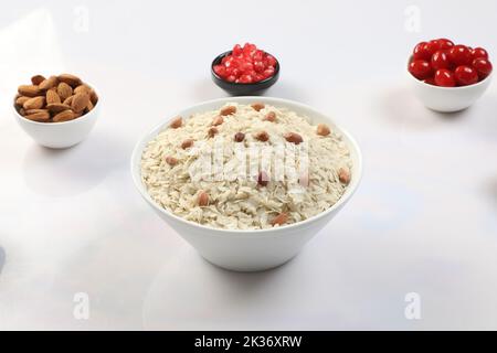 Roher, abgeflachtes Reis oder dicke oder dünne Reisflocken für Namkeen Chivda Snacks oder Aloo Poha für indisches Frühstück, serviert in einer Schüssel. Stockfoto