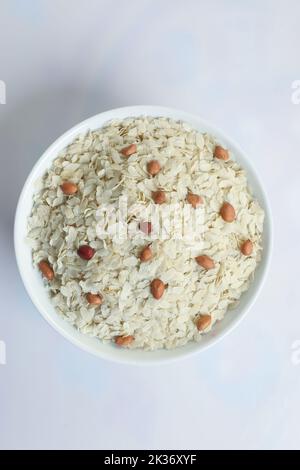 Roher, abgeflachtes Reis oder dicke oder dünne Reisflocken für Namkeen Chivda Snacks oder Aloo Poha für indisches Frühstück, serviert in einer Schüssel. Stockfoto