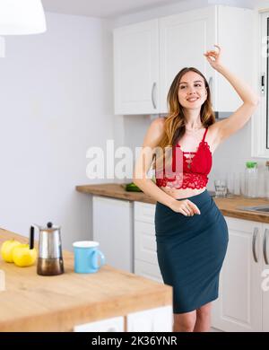 Portrait einer attraktiven Frau viel Spaß beim Tanzen in der Nähe des Tisches Stockfoto