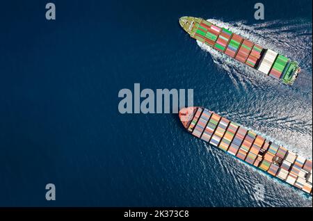 Hohe Luftaufnahme von oben nach unten von zwei Containerschiffen, die über das offene Meer fahren Stockfoto