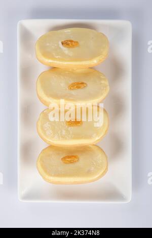 Teller mit traditionellen indischen Süßigkeiten – Laddu, Gulab jamun, Gujiya, Halwa, Barfi. Isoliert auf Weiß. Stockfoto