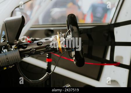 Nahaufnahme des Lenkrads eines Rennwagens, Seitenansicht des Fahrersitzes und des Cockpits Stockfoto