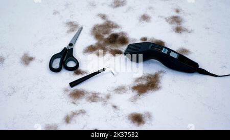 Nahaufnahme von Barber-Werkzeuge und eine Menge von geschnittenen Haaren aus dem Körper, auf weißem Hintergrund. Werkzeuge für Enthaarung, Haarentfernung, Männer Haarschnitt. clipper, Elektrorasierer, Trimer, Schere. Hochwertige Fotos Stockfoto