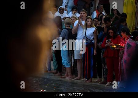 Rishikesh, Uttarakhand, Indien. 23. September 2022. Eifrige Anhänger versammeln sich am Ufer des Ganges Flusses, um an Ganga Aarti teilzunehmen, einem Ritual, das jeden Abend vom spirituellen Führer Swami Chidanand Saraswatiji und Schülern von Parmarth Niketan durchgeführt wird. Parmarth Niketan gegründet 1942 von Pujya Swami Sukhdevanandji Maharaj ist der größte Ashram in Rishikesh, mit über 1000 Zimmern, die eine saubere, reine und heilige Atmosphäre mit reichlich, schönen Gärten für Tausende von Pilgern bieten, die aus allen Teilen der Erde kommen. Zu den täglichen Aktivitäten im Parmarth Niketan gehört tägliches Yoga, spezialisiert auf Vinyasa Yoga, gen Stockfoto