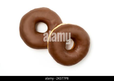 Two Donuts – leckeres Dessert mit glänzendem Schokoladenglasur auf einem Teller, isoliert auf weißem Hintergrund. Ein runder Schokoladen-Donut-Kuchen für Ihr Design und Stockfoto