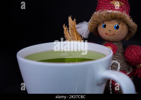 Tasse grüner Tee mit Teeblättern Stockfoto