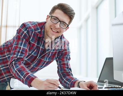 Rückansicht des Geschäftsmannes, der vor dem Laptop-Bildschirm sitzt. Stockfoto