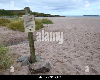 Ein Warnschild (in voller Größe lesbar) an einem schottischen Strand in den Highlands, das über die Vogelgrippe und die Maßnahmen zur Auffindung toter Vögel informiert. Stockfoto