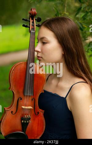 Schönes Mädchen mit Geige in der Natur. Hochwertige Fotos Stockfoto