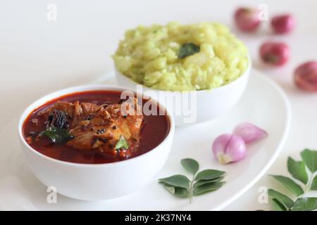 Indisches Butterfischcury im kerala-Stil, serviert mit pürierten Tapioka. Aufgenommen auf weißem Hintergrund Stockfoto