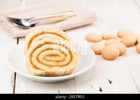 Schweizer Rollkuchen aus Keks und Eierteig. Süßer, leckerer Roulade-Kuchen. Traditionelle Hochzeit und Feier Kuchen. Hausgemachte Bäckerei. Aprikosenmarmelade. Stockfoto