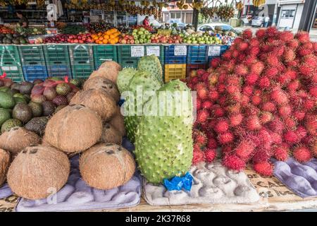 Soursop (Annona muricata), Rambutan (Nephelium lappaceum) und Kokosnüsse (Cocos nucifera) und andere Früchte zum Verkauf auf einem Markt in Costa Rica. Stockfoto