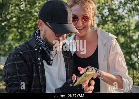 Ein Paar mittleren Alters, das im Freien mit einem Mobiltelefon telefoniert, reist zusammen Stockfoto