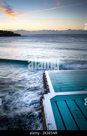 Swimmingpool am Meer in den warmen Tönen des Sonnenaufgangs in Sydney, New South Wales, Australien Stockfoto