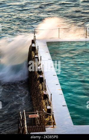Swimmingpool am Meer in den warmen Tönen des Sonnenaufgangs in Sydney, New South Wales, Australien Stockfoto