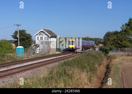 East Midlands Railway Class 170 turbostar fährt an der geschlossenen Signalbox am Roxton-Nebengleis, Lincolnshire, Großbritannien vorbei Stockfoto