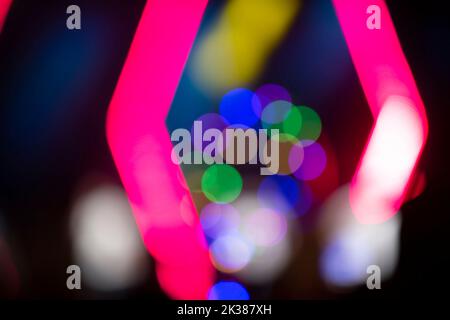 Mehrfarbige Bokeh-Punkte auf dunklem Hintergrund. Festlicher unscharfer Hintergrund. Stockfoto