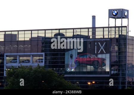 Ein großer BMW-Händlerbetrieb mit einer Plakatwand für sein neues elektrisches Fahrzeug iX wird bei Sonnenaufgang in Toronto beleuchtet. Stockfoto