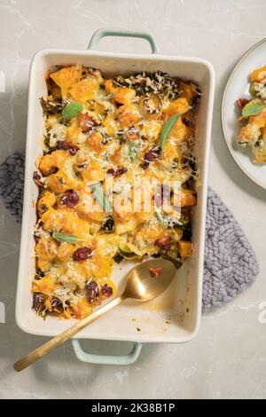 Herbstlicher Kürbisauflauf mit Lauch, Speck und Grünkohl Stockfoto