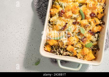 Herbstlicher Kürbisauflauf mit Lauch, Speck und Grünkohl Stockfoto