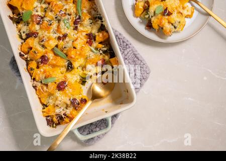 Herbstlicher Kürbisauflauf mit Lauch, Speck und Grünkohl Stockfoto